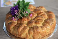 Кръгла погача с мак, украсена с цветя и здравец